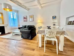 a living room with a table and a couch at ApartHotel Riviera - Maison de la Poissonnerie - Vieille Ville - Grand Appartement 3 piece AC - 5min de la Promenade des Anglais in Nice