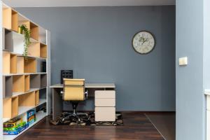 an office with a desk and a chair and a clock at Wyspa Słodowa Serenity Studio in Wrocław