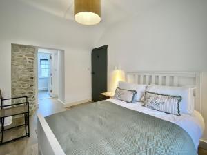 una camera da letto con un grande letto bianco con cuscini di Cottage 478 - Clifden a Clifden
