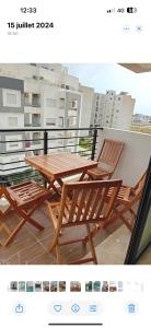 a wooden table and chairs on a balcony at Lynda in Nabeul