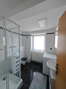 a bathroom with a shower and a toilet and a sink at Apartment O1 - Gut ausgestattete 3-Zimmer Wohnung 78qm für 1-3 Personen 1xDZ 1xEZ in Gravenwerth