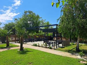 a picnic area with tables and chairs in a park at Garden Apartments in Ulcinj