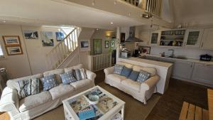 a living room with two couches and a kitchen at Workshop in Saint Mawes