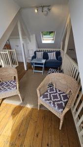 a living room with two wicker chairs and a couch at Workshop in Saint Mawes