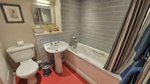 a bathroom with a toilet and a sink and a tub at Workshop in Saint Mawes +21 photos