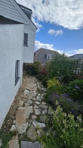 a stone path next to a house with flowers at Workshop in Saint Mawes