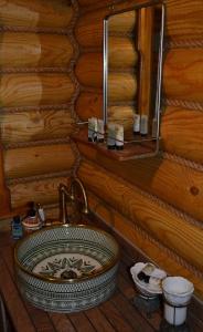 a bathroom with a sink in a log cabin at Traditional Log Cabin next to Harry Potter Studios in Kings Langley +13 photos