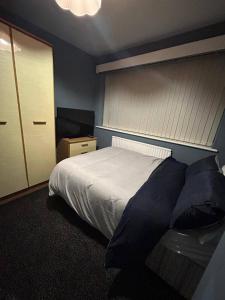 Un dormitorio con una cama y una mesa dentro. en HouseSleeps9-Fireplace-Garden-Bbq-Tv, en Mánchester