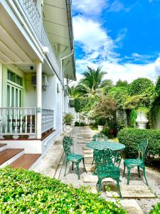 a patio with chairs and a table on a house at Zane Balcony House Ranong Hotel เซน บัลโคนี่ เฮ้าส์ ระนอง in Ban Lum Than