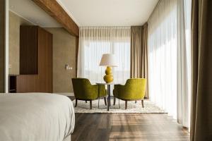 a hotel room with a bed and a table and chairs at Garden Suites with private Jacuzzi in Burgh Haamstede