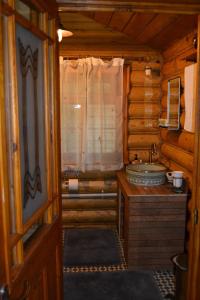 a bathroom with a sink in a log cabin at Traditional Log Cabin next to Harry Potter Studios in Kings Langley