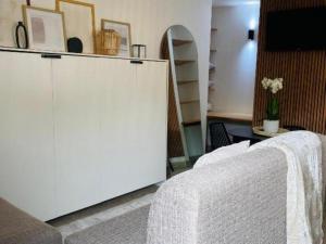 a room with a white cabinet and a bed at Stylish one bedroom apartment close to the beach in Langstrand