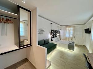 a living room with a green couch and a bedroom at Pansion Episkopi Studios in Skopelos Town