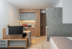 a living room with a television and a kitchen at Ark Urban Living in Kozani