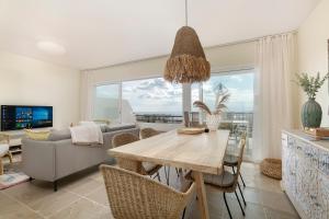 a living room with a dining room table and a couch at Sun-Soaked Home - Panoramic Sea View, Pool, Parking in Manilva