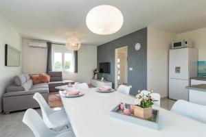 a kitchen and living room with a white table and chairs at Villa Leoni by IstriaLux in Orihi