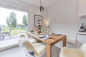 a dining room with a table and chairs with a large window at Treibgut in Norddeich