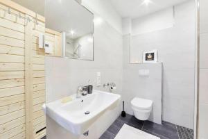 a white bathroom with a sink and a toilet at Treibgut in Norddeich