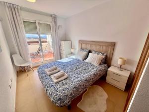 a bedroom with a bed with two towels on it at Condado de Alhama PENTHOUSE SV11 in Alhama de Murcia