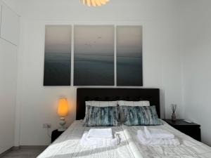 a bedroom with a large bed with two pillows at White 1-bdr apartment Agyos Tychonas in Limassol