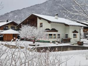 a house covered in snow in front at Haus Gaichtspitzblick in Weissenbach am Lech