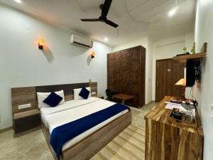 グルガオンにあるHaven Hotel & Corporate Suites, Sector 31, Gurgaonの部屋にベッドと机がある寝室