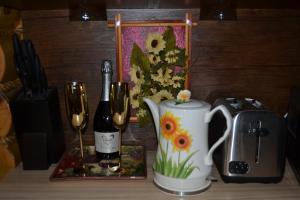 a table with a coffee pot and a bottle of wine at Traditional Log Cabin next to Harry Potter Studios in Kings Langley