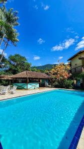 una piscina blu davanti a una casa di Glamping Maresias a Maresias
