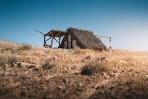 an old building on a hill in a field at Succah in the Desert in Mitzpe Ramon