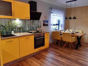 a kitchen with yellow cabinets and a dining table at Ferienhaus Milchstraße mit Sternenblick in Lochow