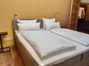 un letto grande con lenzuola e cuscini bianchi di Ferienhaus Milchstraße mit Sternenblick a Lochow