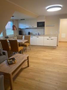 a living room with a table and a kitchen at Ferienhaus Zunftstuben in Norderney