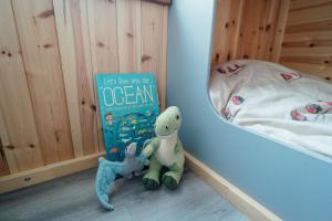 a book and two stuffed animals sitting next to a bed at Glamping Pods in Milngavie +59 photos