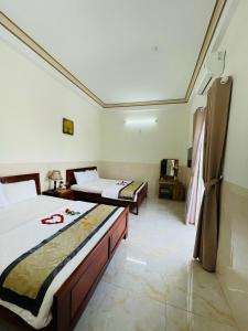 a hotel room with two beds and a room with at Magnolia Hotel Cam Ranh in Cam Ranh