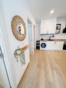 a kitchen with white cabinets and a mirror on the wall at El rincón de María in Torremolinos +2 photos