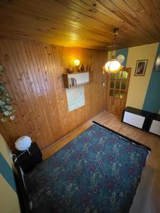 a room with a large bed in a room with wooden walls at Domek w Kotkowie nad jeziorem Gil in Kotkowo