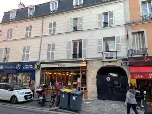 a woman walking down a street in front of a building at Appartements sympas et confortables proche de Paris in Nanterre
