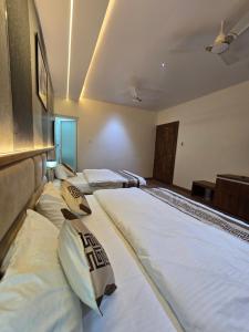 three beds are lined up in a room at Hotel Fortune in Ayodhya