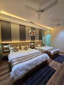 a bedroom with two beds and a ceiling at Hotel Fortune in Ayodhya