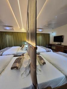 a row of three beds in a hotel room at Hotel Fortune in Ayodhya