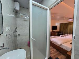 a bathroom with a shower and a bedroom with a bed at Hotel Fortune in Ayodhya