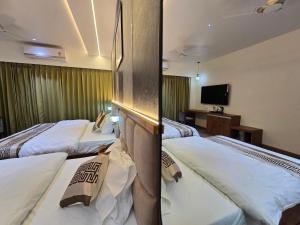 a hotel room with two beds and a television at Hotel Fortune in Ayodhya
