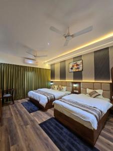 a hotel room with two beds and a ceiling fan at Hotel Fortune in Ayodhya