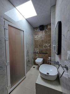 a bathroom with a toilet and a sink and a shower at Hotel Fortune in Ayodhya