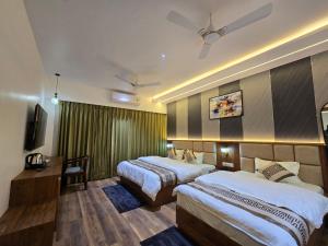 a hotel room with two beds and a tv at Hotel Fortune in Ayodhya