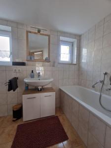 a bathroom with a sink and a bath tub at Ferienwohnung Alpenhirsch Schwangau in Schwangau +13 photos