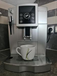 a coffee machine with a cup on a counter at Apartman Jugi in Brdovec