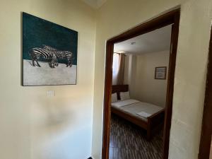 a room with a mirror and a picture of zebras at Town Retreat Moshi in Moshi