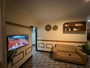 a living room with a couch and a flat screen tv at Town Retreat Moshi in Moshi