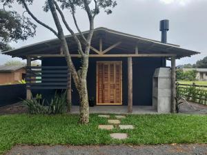 a blue house with a tree in front of it at Casa nova a 2 min do mar in Arroio do Sal